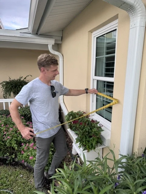 GulfGuard team member taking detailed window measurements at a Florida home.